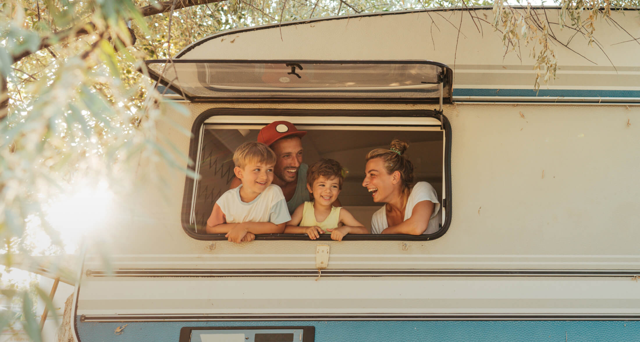 family with small children standing in a camper window