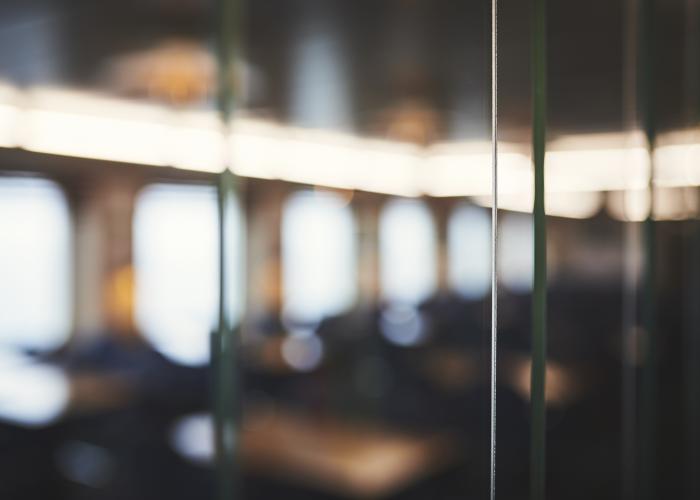 A blurry, unfocused image of a window overlooking what might be a seating area inside a Marine Atlantic ferry.