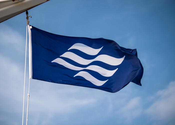 mai_flag_ma-day-two-d4s-b-839_flipped_marine_atlantic_flag-2017-shoot The royal blue Marine Atlantic flag with undulating white wave emblem blows in the wind onboard a ferry.