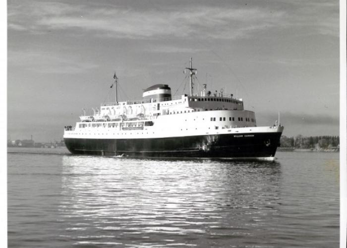 Side shot of the MV William Carson sailing away from the port