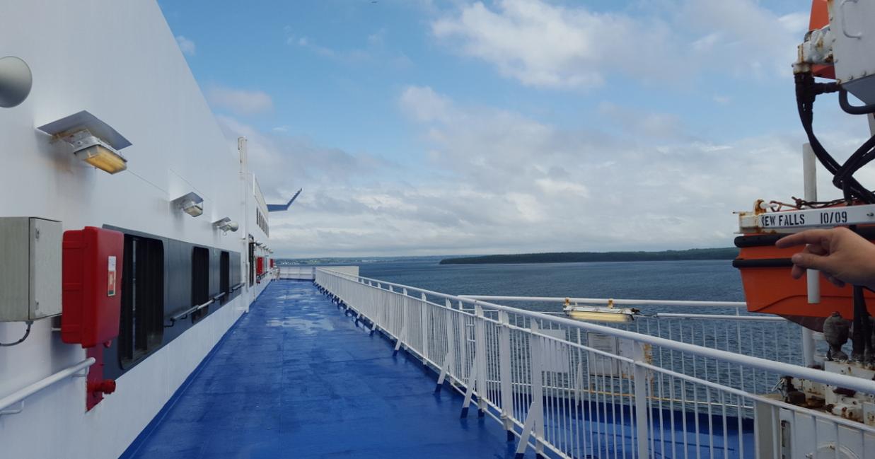 Image: top deck of a vessel, ocean view in the background.