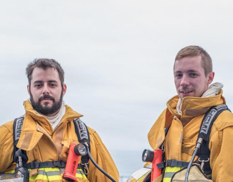 Two firefighters standing outside