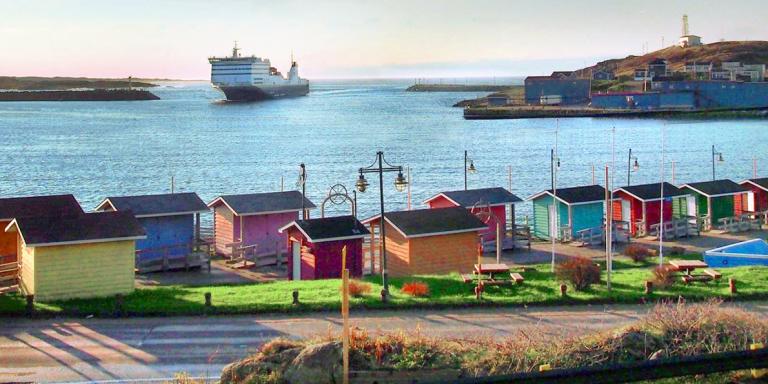 View of Scott's Cove colourful buildings with ferry in the background