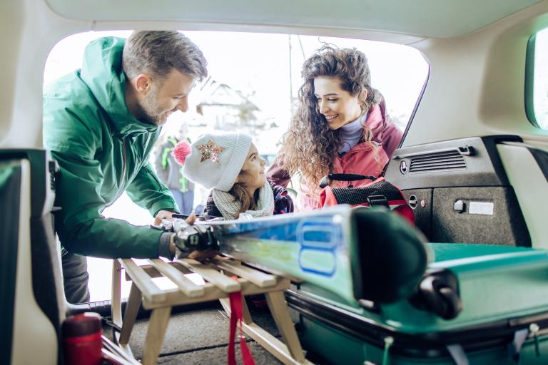 Couple and child packing up car for holidays