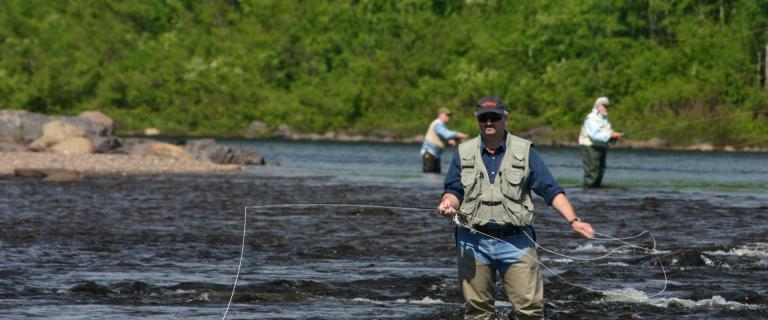 man fishing knee deep in water