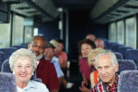 a group of seniors sit on a tour bus