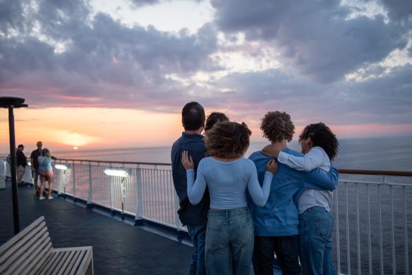 Family of five looking out at the sunset on the outdoor viewing deck