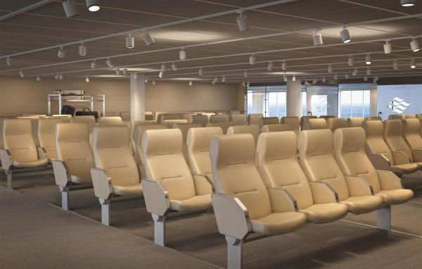 Rows of reclining seats in an open lounge area with large windows and overhead lights
